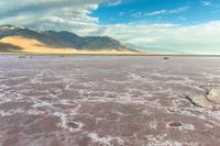 an area with mountains, rocks and water in the middle of the desert with sparse grass