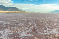 an area with mountains, rocks and water in the middle of the desert with sparse grass