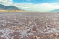 an area with mountains, rocks and water in the middle of the desert with sparse grass