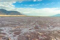 an area with mountains, rocks and water in the middle of the desert with sparse grass