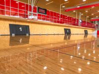 a basketball court with wooden floors and wood walls in the center of it is red