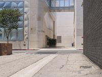 a street corner with a paved sidewalk and some tall buildings in the background of this photo