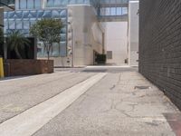 a street corner with a paved sidewalk and some tall buildings in the background of this photo