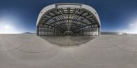 a half way view of a circular mirror and a skateboard ramp at an empty skating center