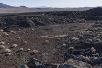 the barren area of an arid area of the desert, with mountains in the distance