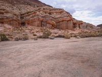 the rocks are red with white, orange and brown formations of a mountain range in the background