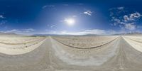 a 360 - effect image of an arid area and desert with a lot of tracks in the middle