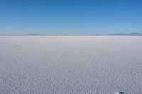 a picture of there is only a person on that snow field and a very blue sky in the background