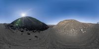 a photo of two large mounds of rocks and dirt in the desert with a sunbeam