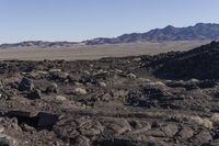 a rocky desert and mountains in a clear sky time lapsuck with shallow clouds and low sun