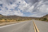 the view of a deserted highway and mountains on the horizon is as though in motion