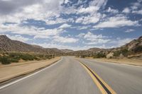 the view of a deserted highway and mountains on the horizon is as though in motion