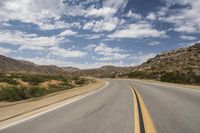 the view of a deserted highway and mountains on the horizon is as though in motion