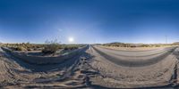 a desert road with some tracks that appear to be dirt and sand under a sunray