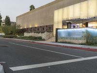 a street in an area of desert with motel signs on the side and a desert road behind