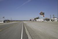 a street in an area of desert with motel signs on the side and a desert road behind