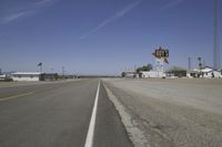 a street in an area of desert with motel signs on the side and a desert road behind