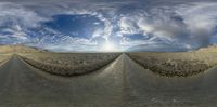 two roads in the desert with a large sunset in the background and clouds in the sky