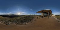 a 360 - angle shot of a dirt track with a building in the distance that reads a winery