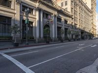 an empty city street with a row of buildings on both sides of it and a crosswalk to the left