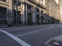 an empty city street with a row of buildings on both sides of it and a crosswalk to the left