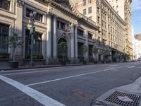 an empty city street with a row of buildings on both sides of it and a crosswalk to the left