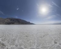 an open plain with no people in it at the bottom and snow on the ground