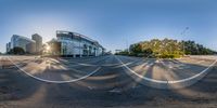 a panoramic view of a wide open lot with buildings, streets, and a bus stop