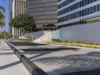 people are walking down a sidewalk in front of a tall building with windows and a stair