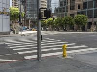 a yellow fire hydrant sitting on the side of a street near a crosswalk