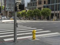 a yellow fire hydrant sitting on the side of a street near a crosswalk