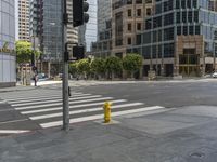 a yellow fire hydrant sitting on the side of a street near a crosswalk