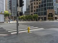 a yellow fire hydrant sitting on the side of a street near a crosswalk