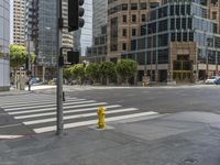 a yellow fire hydrant sitting on the side of a street near a crosswalk