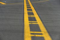 a yellow painted street arrow on the ground leading towards an airport with people in black