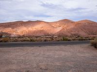 mountains with trees and dry shrubs are shown in the foreground of the desert landscape