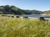 view from the side of a highway with a large body of water and hills in the background