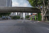 an elevated bridge over a city street with tall buildings on either side of the road