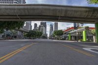 an elevated bridge over a city street with tall buildings on either side of the road