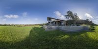 a big house sitting on top of a grass covered hillside next to a hill side