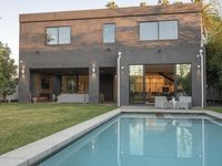 a house that has been renovated and designed with a large swimming pool in front of it