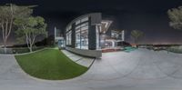 a 360 - view lens view of a house at night with its backyard and pool