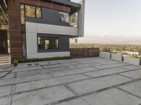 the exterior and landscape of a modern house in los angeles, california with stone and wood