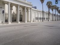 this is a large building with columns on the front and sides of it and palm trees