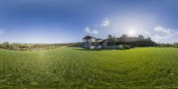 an image of a big house in the middle of some grass on the hill area