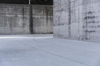 a skateboard is laying on a cement floor in an empty concrete building with no one on it