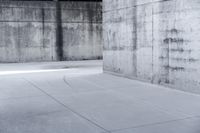 a skateboard is laying on a cement floor in an empty concrete building with no one on it