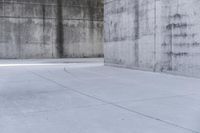 a skateboard is laying on a cement floor in an empty concrete building with no one on it