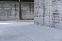 a skateboard is laying on a cement floor in an empty concrete building with no one on it