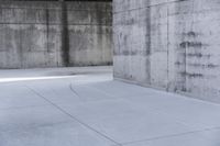 a skateboard is laying on a cement floor in an empty concrete building with no one on it